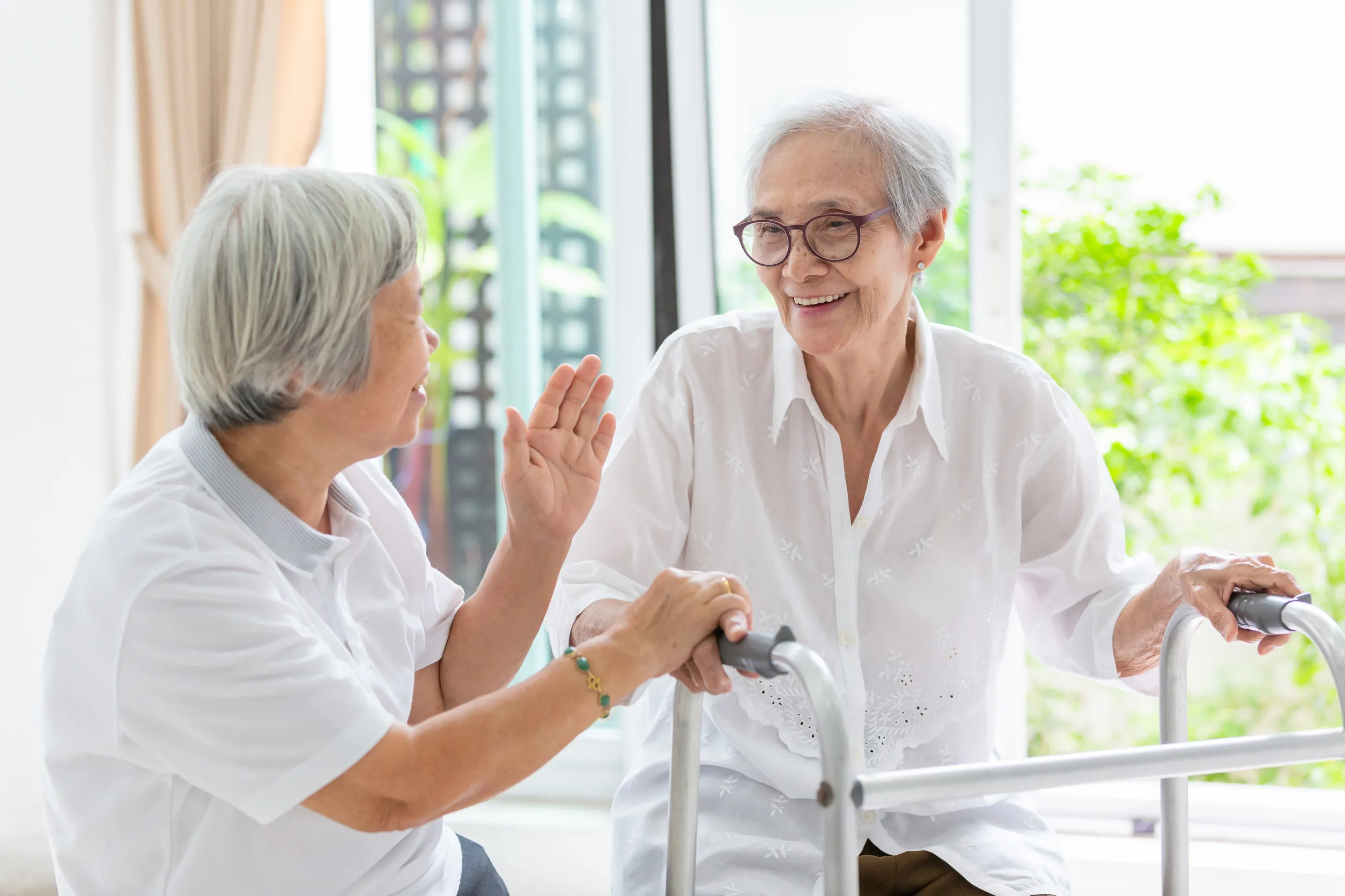 Happy two asian senior women friends holding hands for care,support and fun talking,time together Happy two asian senior women friends holding hands for care,support and fun talking,time together